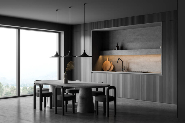 Panoramic dark grey kitchen interior, having niche, oval table with stools, panoramic window, concrete floor and three pendant lamps. A concept of modern house design. Corner view. 3d rendering - Photo, image