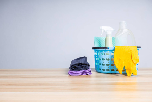 Korb mit Reinigungsmitteln auf Holztisch, Reinigungsdienstleistungen und Coronavirus-Schutzkonzept - Foto, Bild
