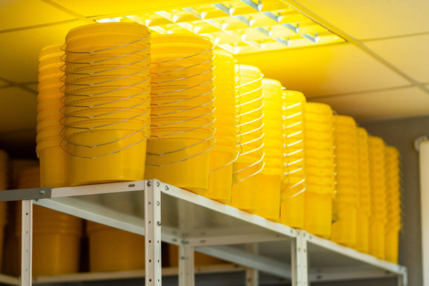 Many yellow color buckets cans in row with ink paint row - Photo, Image
