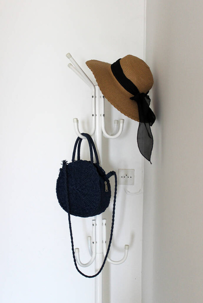 капелюх і літня сумка на вішалці
 - Фото, зображення