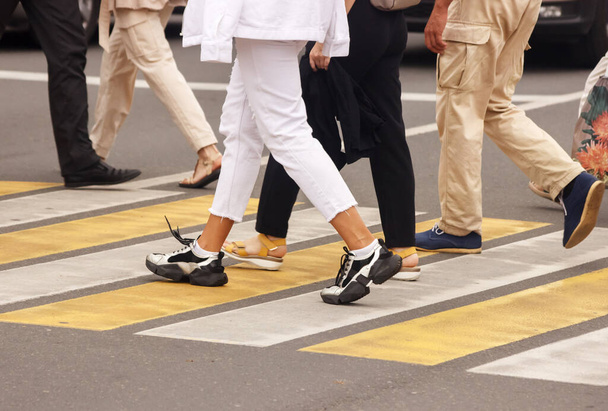 пешеходы ходят по пешеходной дорожке в солнечный летний день - Фото, изображение