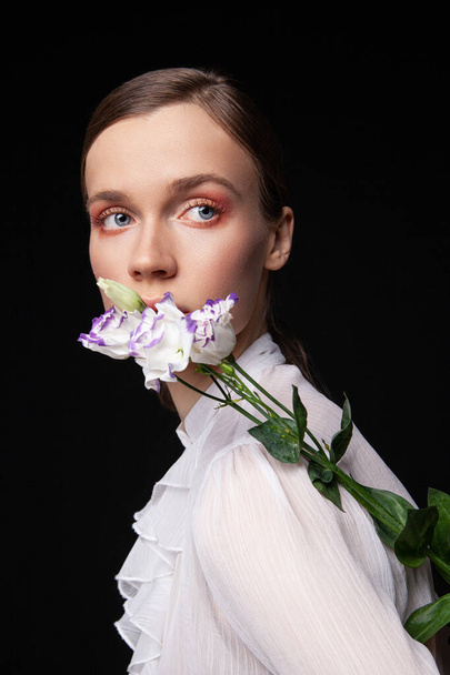 Elegant young female model with delicate flowers - Foto, Imagen
