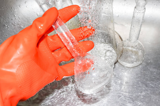 手袋で実験室の化学ガラスをきれいにする - 写真・画像