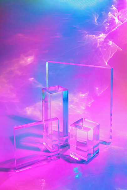 dos podios de prisma rectángulo de vidrio transparente sobre fondo de neón pastel  - Foto, imagen