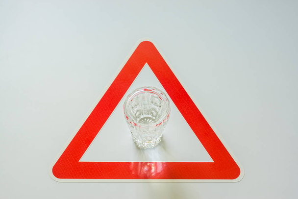 Αλκοόλ σφηνάκι βότκα σε κόκκινο τρίγωνο σε λευκό φόντο - Φωτογραφία, εικόνα