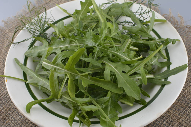 Friss zöld rukkola az asztalon. Arugula rucola salátának. Közelről friss, zöld, egészséges ételeket. Diétás fogalom. - Fotó, kép