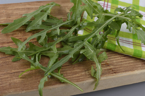 Friss zöld rukkola az asztalon. Arugula rucola salátának. Közelről friss, zöld, egészséges ételeket. Diétás fogalom. - Fotó, kép