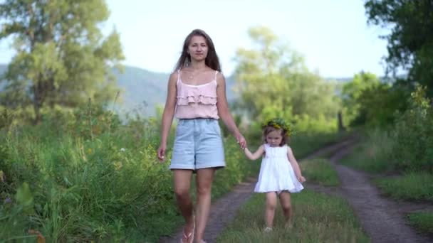 šťastná matka a dcera s květinovým věncem procházka po venkově - Záběry, video