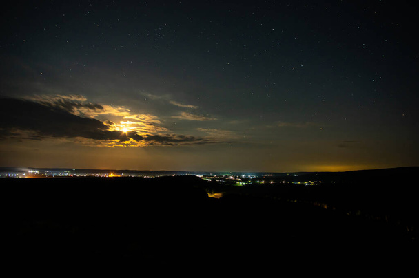 місяць освітлений літньою ніччю біля села в полі в украйні - Фото, зображення