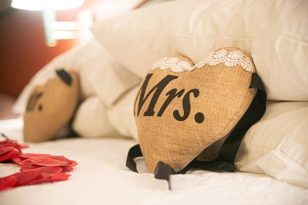 Almohadas Beige Mr. & Mrs. Heart con encaje blanco y letras negras en una cama - Foto, imagen
