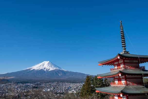 The iconic view of Mount Fuji with the red Chureito pagoda and Fujiyoshida city from Arakurayama sengen park in Yamanashi Prefecture, Japan. - Photo, Image