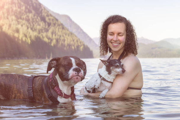 Caucasian Woman swimming in a lake with dog - Фото, зображення
