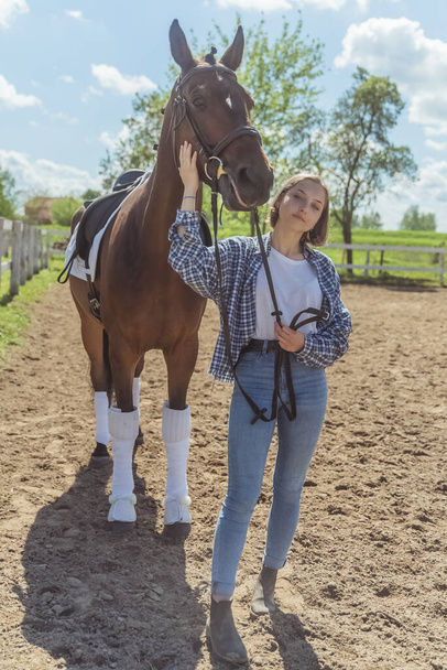 Girl With Her Dark Bay Horse Posing In The Sandy Arena During The Daytime - Foto, afbeelding