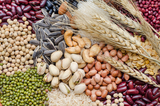 Tipo de variedade de grãos e cereais orgânicos secos empilhados com pacote de trigo seco em tom escuro, para ingredientes alimentares saudáveis ou limpos ou conceito de produto agrícola - Foto, Imagem