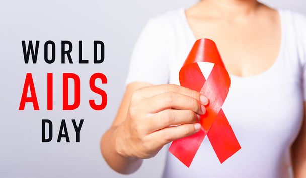 Closeup of female with red ribbon HIV AIDS on hand, World AIDS Day and medicine concept - Fotoğraf, Görsel