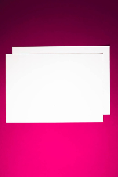 Papel A4 en blanco, blanco sobre fondo rosa como plano de papelería de oficina, diseño de identidad de marca de lujo y diseño de identidad de marca para maqueta - Foto, Imagen