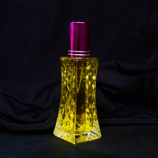 parfum avec liquide jaune sur fond noir - Photo, image
