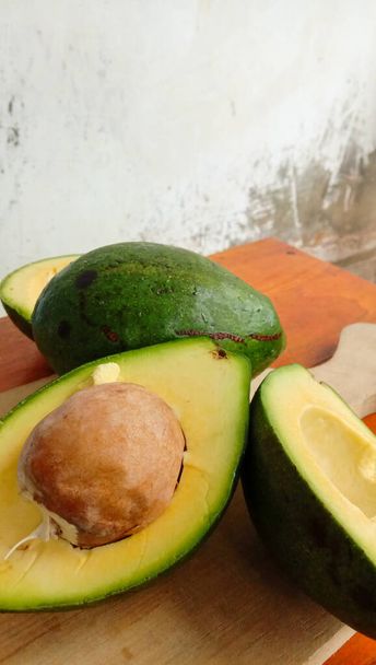 A photo of an avocado that has been split on a table - Fotografie, Obrázek