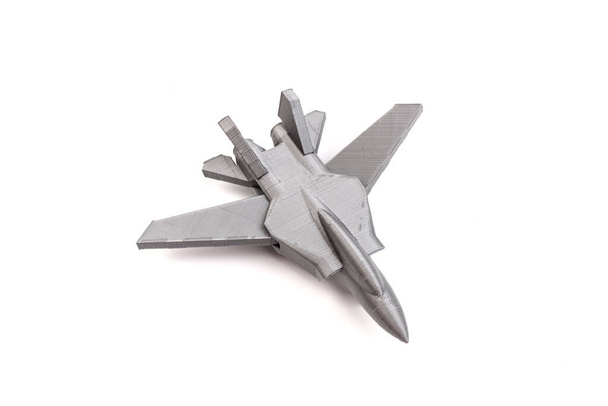 Model szary miniaturowy myśliwiec stworzony na drukarce 3D, na białym tle. koncepcja transportu - Zdjęcie, obraz