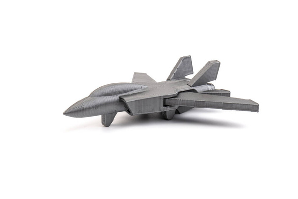 3Dプリンターで作成されたモデルグレーのミニチュア戦闘機は、白い背景に。交通概念 - 写真・画像