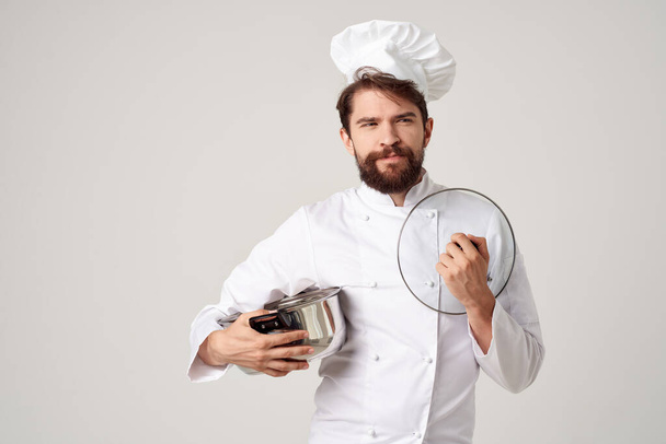 Chef masculin joyeux avec une casserole dans les mains d'un aliment de cuisine professionnelle - Photo, image