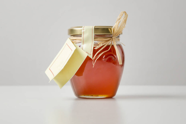 A jar of honey or sweet syrup on the table - Фото, зображення