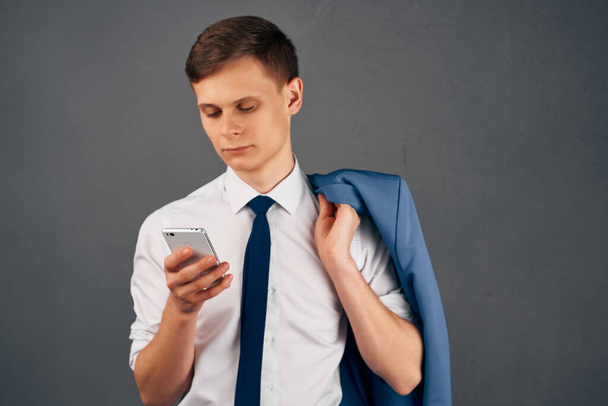 business man with a jacket on his shoulder with a phone communication internet technology work - Foto, Imagen