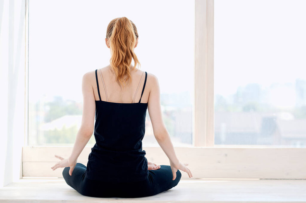 donna vicino alla finestra yoga prestazioni meditazione flessibilità - Foto, immagini