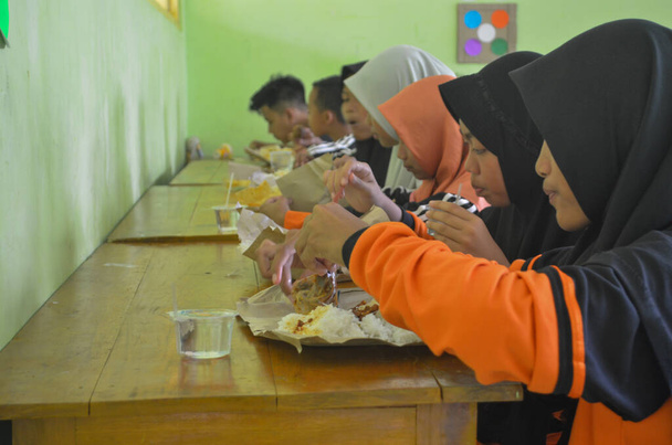 15 de abril de 2018, fotos de niños de secundaria y secundaria vocacional comiendo juntos, Wadaslintang, Wonosobo, Indonesia - Foto, imagen