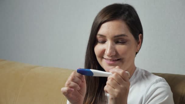 Primer plano de la mujer joven felizmente mirando la prueba de embarazo - Metraje, vídeo