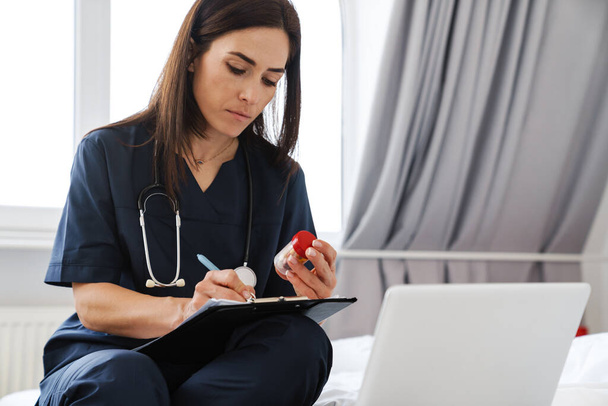 General practitioner female doctor writing a prescription online via video call - Foto, imagen