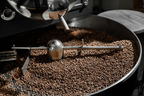 Coffee processing. Roastery, roasting machine and fresh beans - Foto, imagen