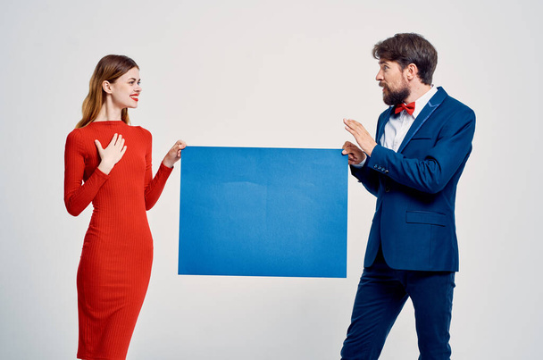 mężczyzna i kobieta w garniturach stwarzających przestrzeń reklamową - Zdjęcie, obraz