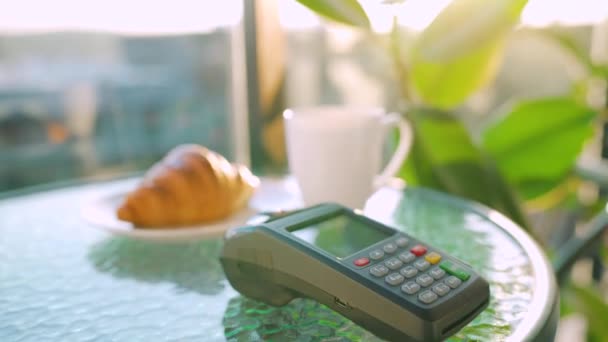 NFCクレジットカード決済。カフェでNFC技術と非接触クレジットカードで支払う女性。無線資金取引だ。ワイヤレス決済 - 映像、動画