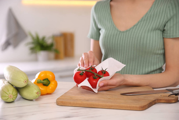 Woman wiping tomatoes with paper towel in kitchen, closeup - Φωτογραφία, εικόνα