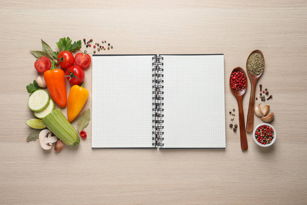 Blank recipe book and different ingredients on wooden table, flat lay. Space for text - Foto, Bild
