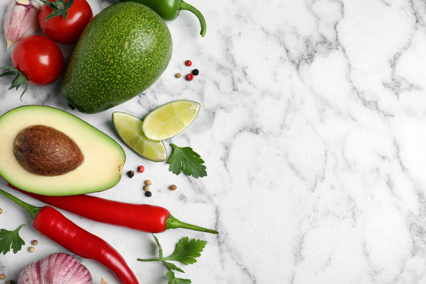 Fresh guacamole ingredients on white marble table, flat lay. Space for text - Foto, Imagem