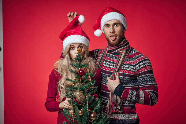 Yeni yıl kıyafetleri içindeki kadın ve erkek Noel 'i birlikte kutluyor. - Fotoğraf, Görsel