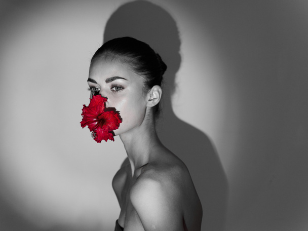 Kadın kırmızı çiçek çıplak omuzlar stüdyo cazibesi siyah beyaz fotoğraf - Fotoğraf, Görsel