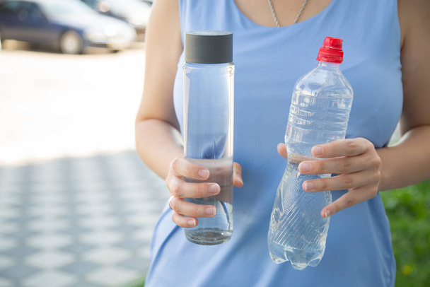 glass bottle instead of plastic water bottle, environmental protection, water splash, green grass - Fotoğraf, Görsel