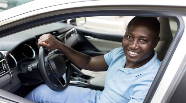 Усміхаючись африканським американцем, який сидить в автомашині - Фото, зображення