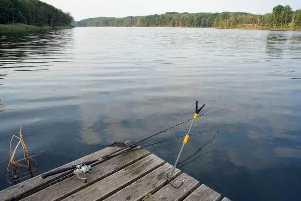 Varillas tumbadas en una plataforma de madera en el lago - Foto, imagen