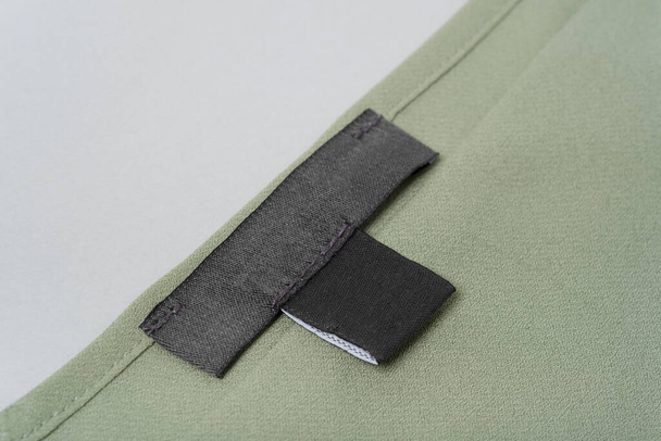 mockup fekete Üres címke egy zöld khaki blúzon közelkép. - Fotó, kép