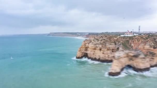 Aerial drone hiper lapse krążące wokół pięknej linii brzegowej Lagos Algarve z falami uderzającymi o skaliste klify, pochmurny dzień Hyperlapse - Materiał filmowy, wideo