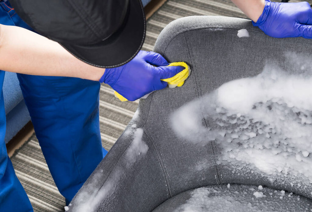 close-up of cleaning a gray chair with thick white foam and a rag, by hand - Fotoğraf, Görsel