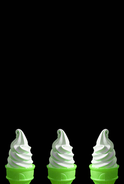 Drie van Bright Green Lime Soft Serve Ice Cream kegels op zwarte achtergrond - Foto, afbeelding