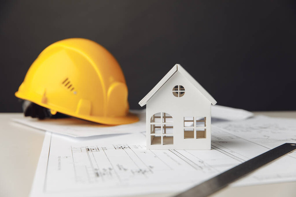 Planos de construcción con casco amarillo y modelo de casa - Foto, imagen