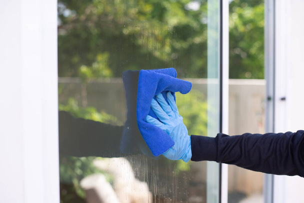 A férfi kéztisztító ablaküveg közelsége, ablakok és ajtók tisztítása otthon. - Fotó, kép