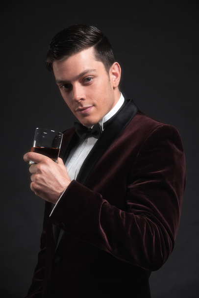 Well dressed good looking business man holding glass of whiskey. - Fotoğraf, Görsel