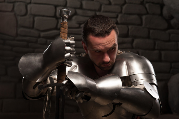 Medieval knight kneeling with sword - 写真・画像